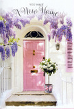 This scene shows a sunlit entrance that could belong to a quietly tucked-away home in Shooter's Hill, beautifully styled as though a local florist has just finished preparing it for a new homeowner's arrival. A pale pink front door, painted in a gentle, comforting shade, holds the eye, with a single matching shutter nearby echoing the same blush tone. Above, cascades of wisteria spill down in graceful lavender drifts, their drooping clusters forming an almost theatrical curtain around the door. The blossoms are a mix of soft lilac and muted violet, suggesting that they are caught at the height of spring, much like the flowering vines you might see climbing over garden walls around Shooters Hill and near Oxleas Woods. You can almost imagine the soft fragrance carried on a light breeze.   

The walls are whitewashed, slightly rough and timeworn, yet glowing warmly in the sunlight, which creates dappled shadows that dance gently over the doorway and steps. At the threshold, a generous arrangement rests in a chic grey bucket, its surface subtly brushed and slightly rustic. From this container, an abundance of white and cream roses overflows, their petals layered and velvety, each bloom opened to its full, romantic shape. Interwoven with the roses are sprigs of soft green foliage, adding depth and a whisper of garden freshness. Around the base of the bucket, a satin-finish ribbon in soft pink is tied into a graceful bow, its loose ends curling slightly. Everything about this composition-door, flowers, ribbon, and light-feels like a blessing for new beginnings, a floral way of saying, welcome home to Shooter's Hill; may every step through this doorway be wrapped in comfort, optimism, and quiet joy.
